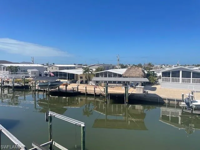 Dock with a water view, a residential view, and boat lift