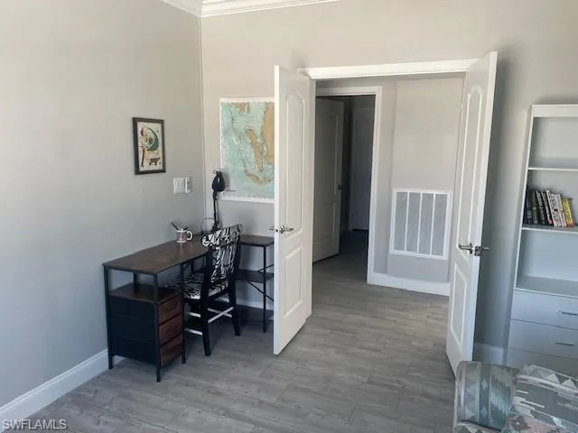 Office with light wood-style flooring and baseboards