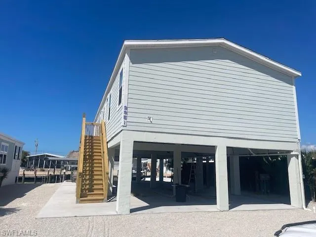 View of property exterior featuring stairway and a patio area