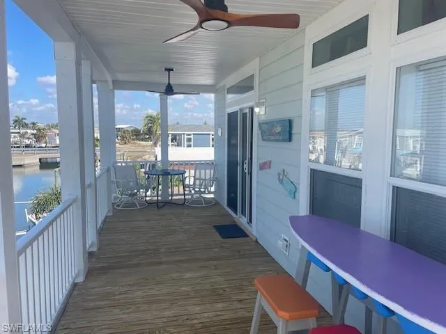 Wooden porch with a ceiling fan and a water view
