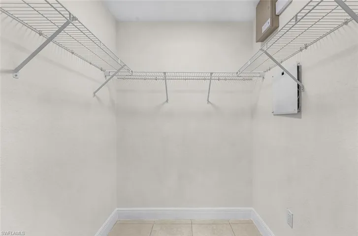 Spacious closet with light tile patterned floors