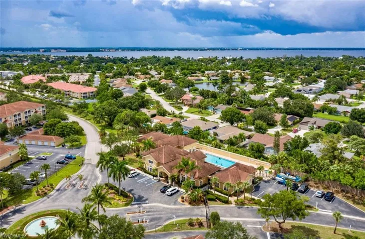 Aerial view of residential area with a large body of water and a pool