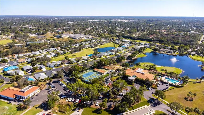 Aerial perspective of suburban area with a large body of water and a golf course