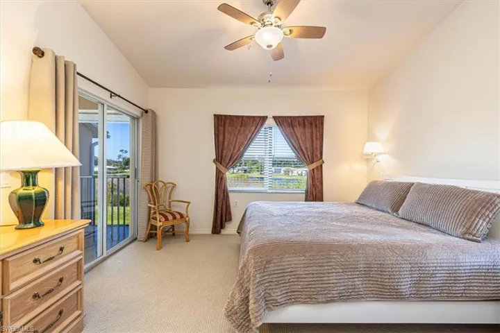 Bedroom with access to outside, light colored carpet, and ceiling fan