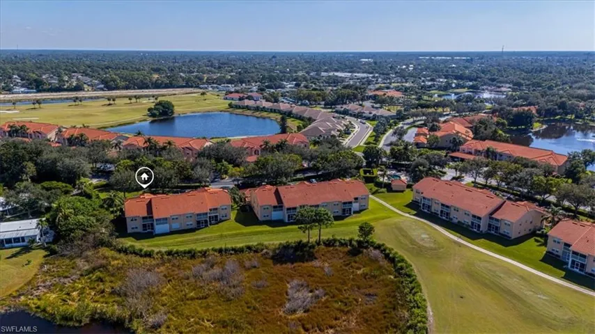 Aerial perspective of suburban area with a nearby body of water and a local golf course