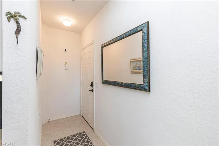 Doorway to outside with tile patterned flooring and a textured wall