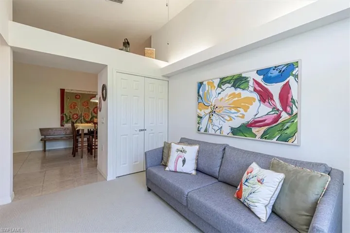 Living area featuring carpet, a high ceiling, and tile patterned flooring