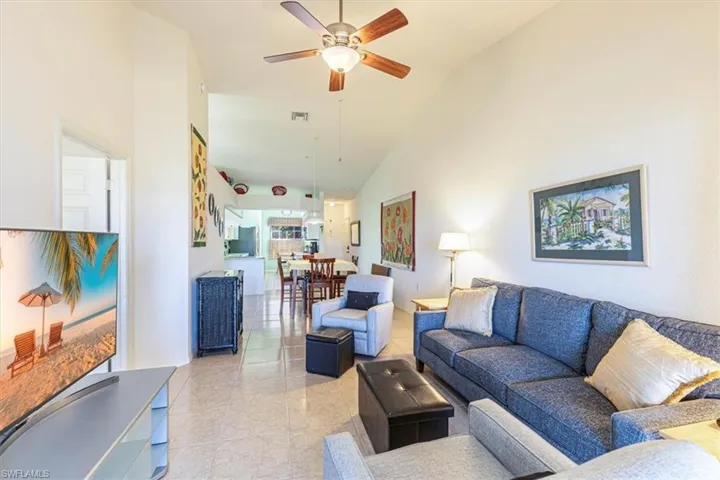Living area featuring ceiling fan and high vaulted ceiling
