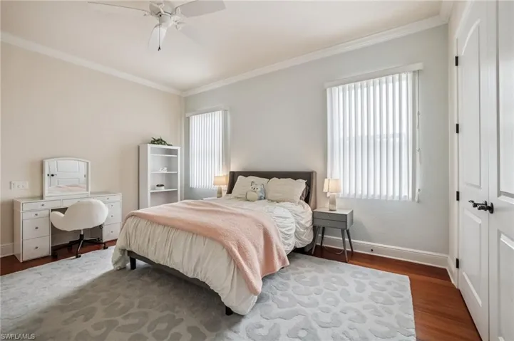 Bedroom featuring ornamental molding, a closet, wood finished floors, and ceiling fan