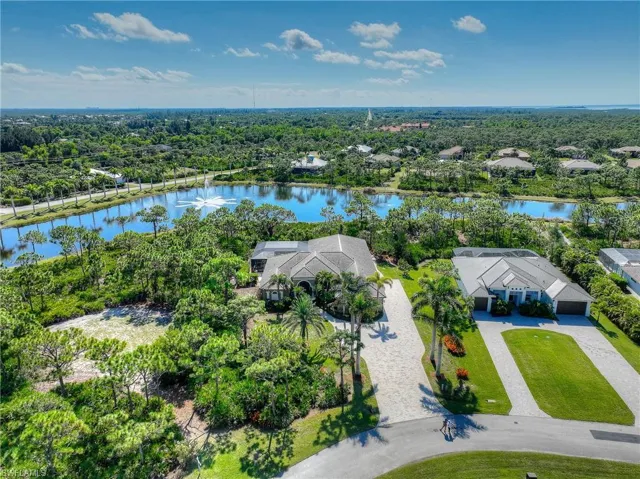 Bird's eye view of home, community lake and a tree lined landscape