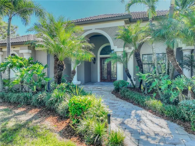 View of exterior entry with a tile roof, stucco siding, and french doors