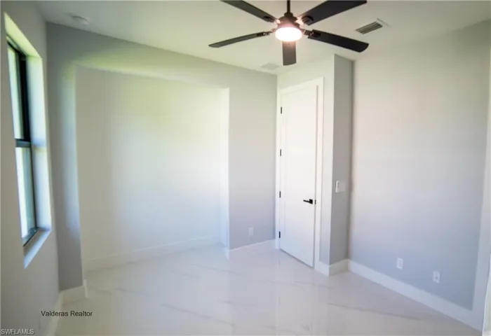 Unfurnished bedroom with a ceiling fan and baseboards