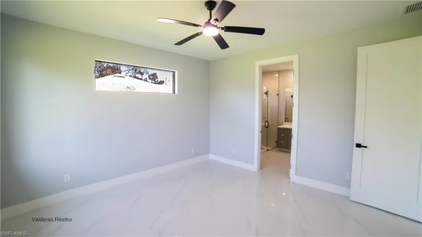 Unfurnished bedroom with a ceiling fan and ensuite bathroom