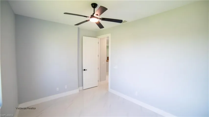 Spare room with light marble finish flooring and ceiling fan