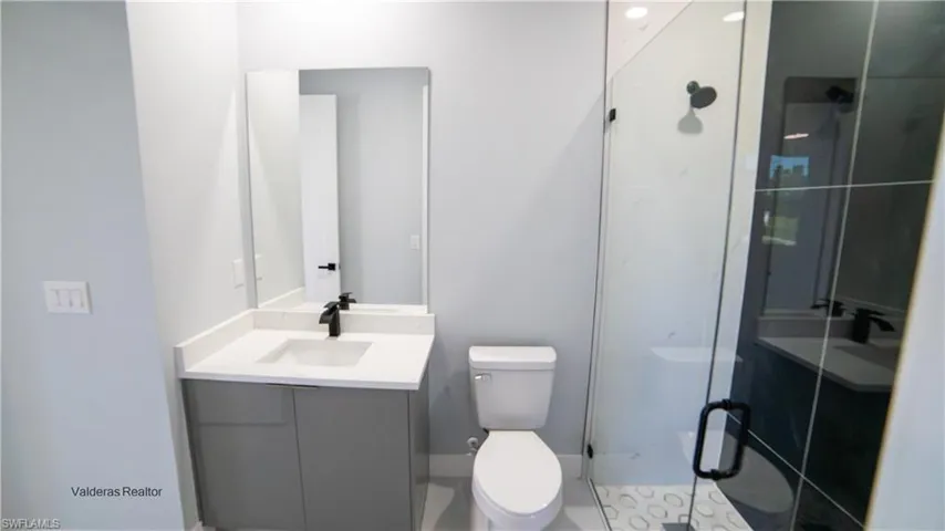 Bathroom featuring vanity and a shower stall