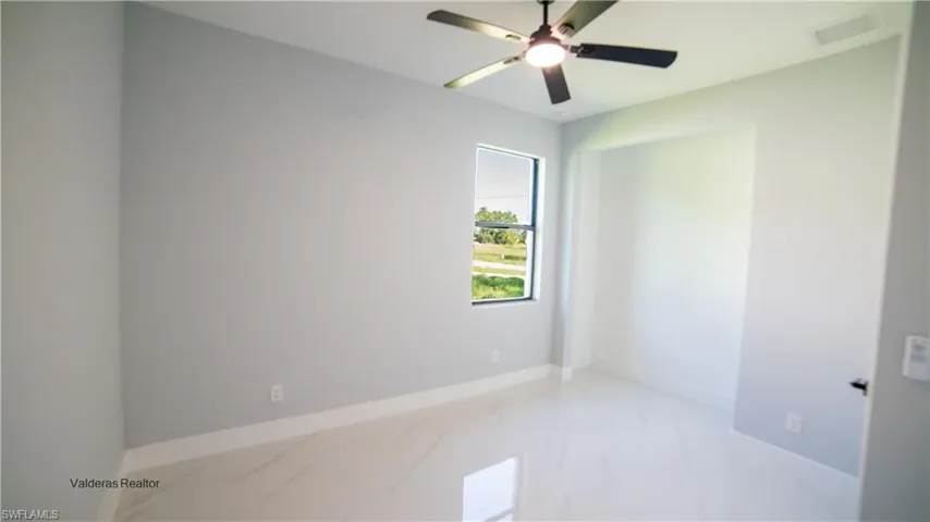Unfurnished room with light marble finish flooring and a ceiling fan