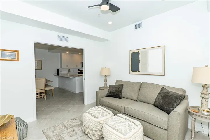 Living room with ceiling fan, light tile patterned floors, and recessed lighting