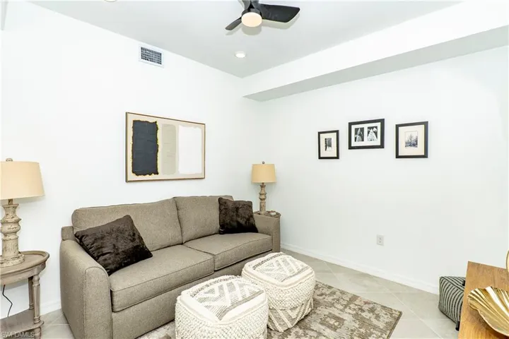 Living room with a ceiling fan, light tile patterned floors, and recessed lighting