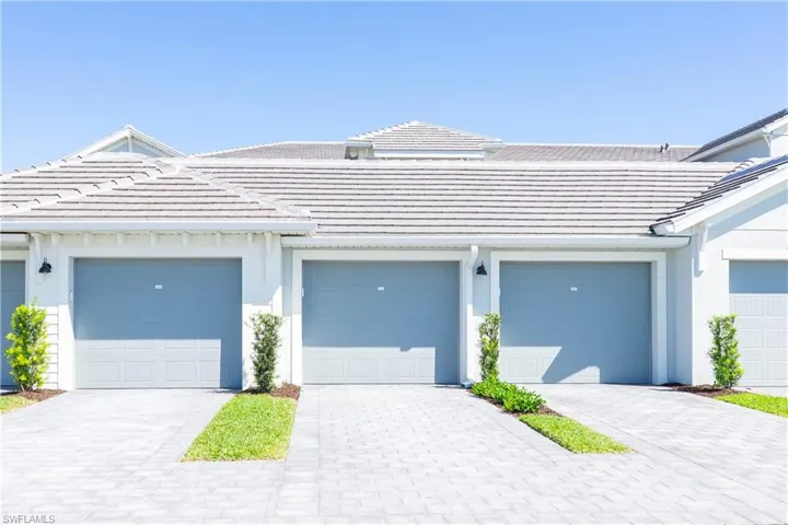 View of property featuring a tiled roof and stucco siding