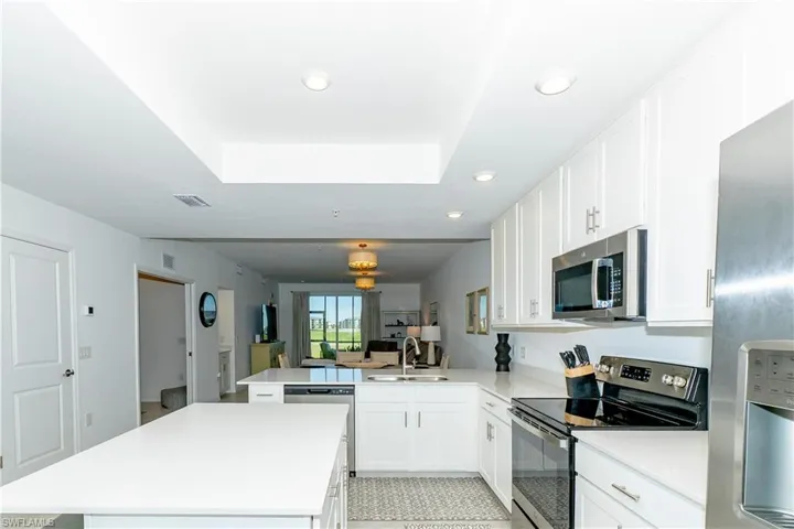 Kitchen featuring stainless steel appliances, a peninsula, recessed lighting, a kitchen island, and light countertops