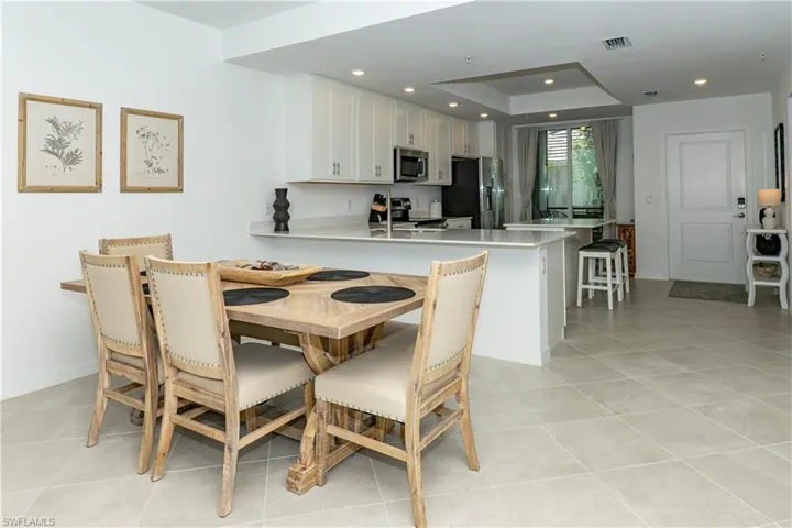 Dining space with recessed lighting and light tile patterned floors