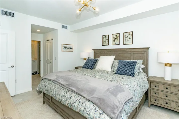 Bedroom with tile patterned floors, a chandelier, and a closet