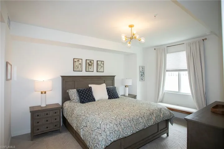 Bedroom with tile patterned flooring and a chandelier