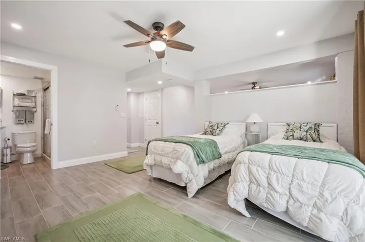 Bonus space currently used as a bedroom with connected full bath. Sliders leading to a screened patio and bay, pool and boat slip beyond.