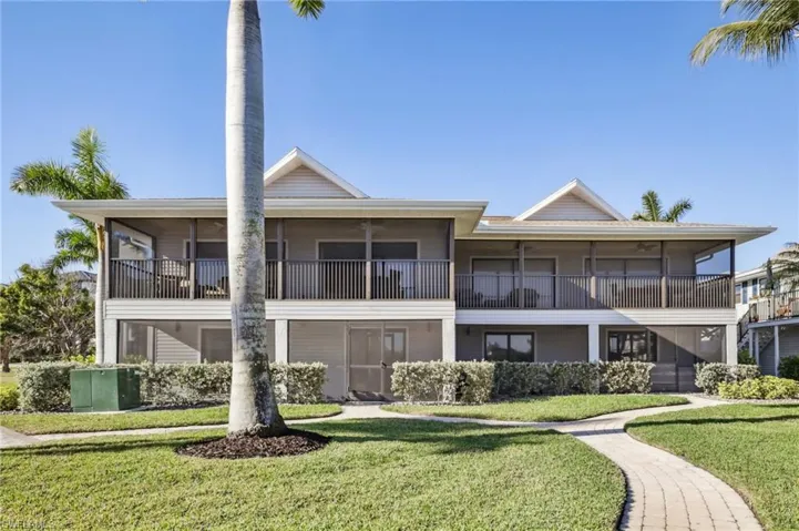 View looking to the rear of the home and its balcony and patio. The pathway leads you to the Pool on your left from the patio or straight ahead (behind this shot) to the dock for fishing or putting your boat into the bay!