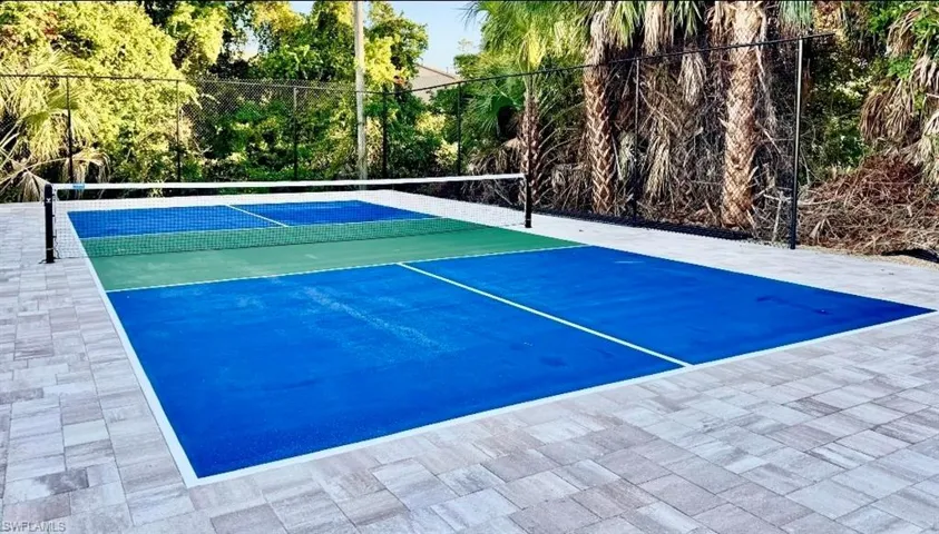 View of tennis court with view of scattered trees