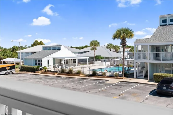 Uncovered parking lot featuring stairs and a community pool