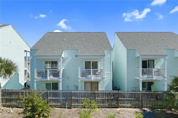 Rear view of property with a balcony and roof with shingles