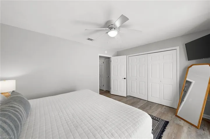 Bedroom with light wood-style flooring, a ceiling fan, and a closet