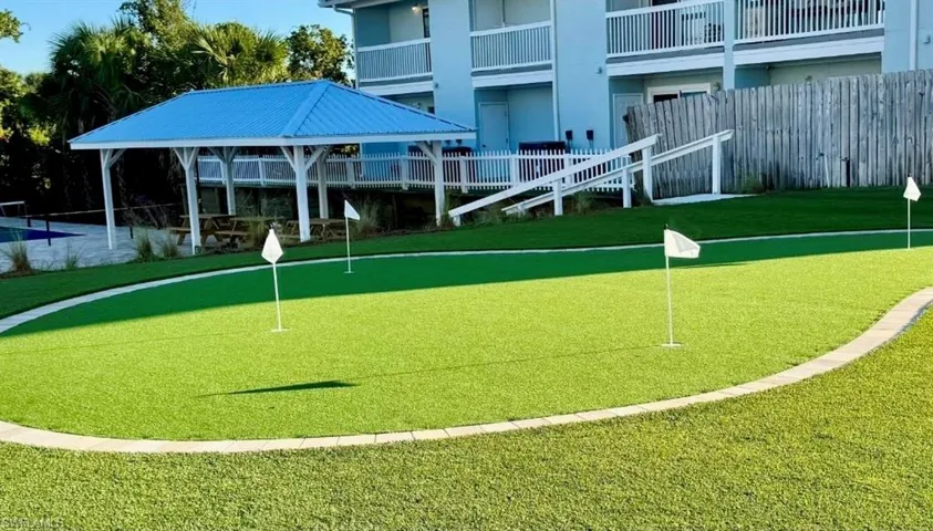 View of home's community with a putting area and a lawn