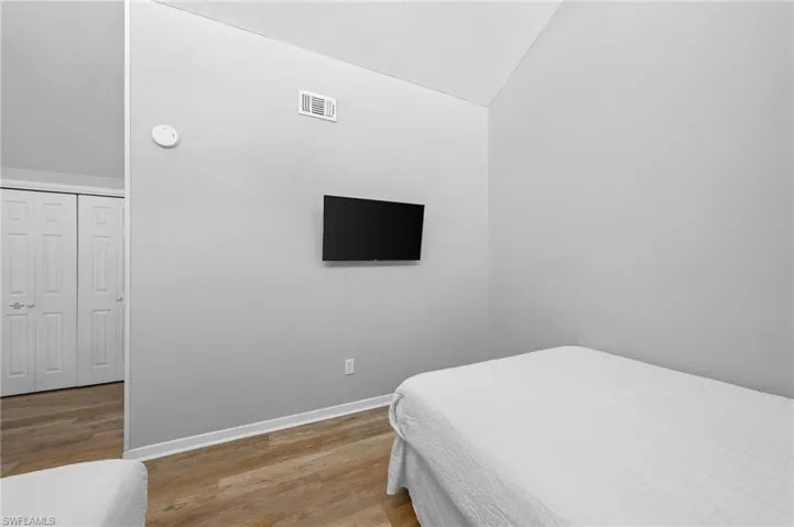 Bedroom with lofted ceiling and light wood finished floors