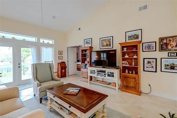 SPACIOUS LIVING AREA.  FRENCH DOORS (WITH TRANSOM WINDOW) LEAD TO UPPER SCREENED DECK.  DOOR AT MIDDLE REAR IS TO OWNER'S SUITE.