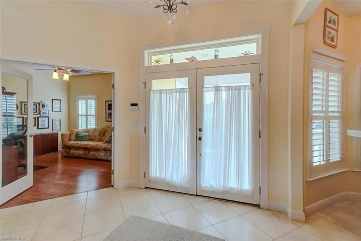 VIEW FROM LIVING AREA SHOWING HOME ENTRANCE, ENTRANCE TO DEN/FLEX ROOM (LEFT) FORMAL DINING ROOM (RIGHT).  PLANTATION SHUTTERS THROUGHOUT.  LARGE DIAGONAL TILE THROUGHOUT MAIN LIVING AREA.  SECURITY SYSTEM.