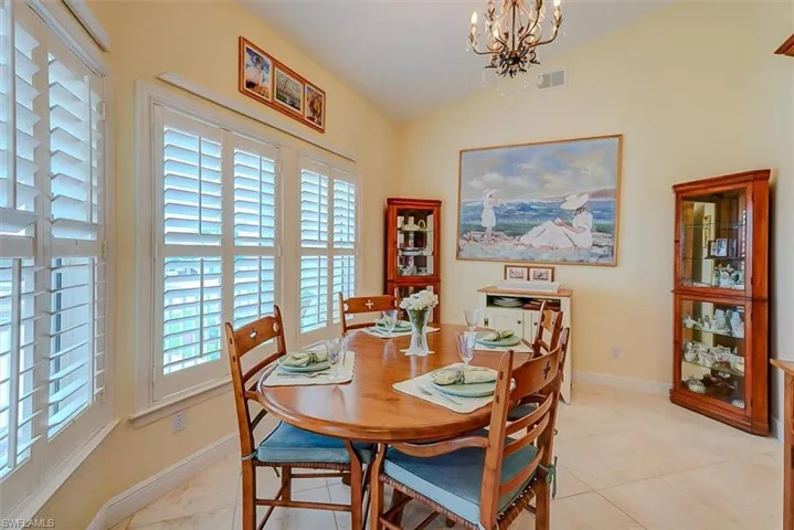 FORMAL DINING SPACE.  PLANTATION SHUTTERS GRACE IMPACT RESISTANT WINDOWS.  ENTRANCE TO KITCHEN IS TO RIGHT.