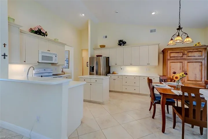 BEAUTIFUL EAT-IN KITCHEN WITH SOLID SURFACE COUNTERTOPS, UNDER-CABINET LIGHTING.  CONVENIENT WORK ISLAND.  REFRIGERATOR IS ONLY A FEW MONTHS OLD.  ENTRANCE TO GUEST BEDROOMS, GUEST BATH AND LAUNDRY ROOM IS MIDDLE REAR.