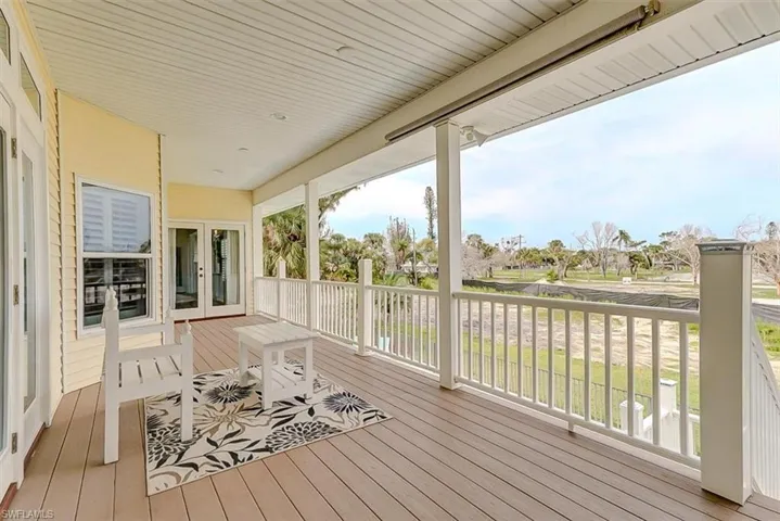 BIG OPEN UPPER DECK FACES THE GULF OF MEXICO.  BEADBOARD CEILING.  COMPOSITE DECKING. GUEST SUITE ENTRANCE IS SHOWN AT MIDDLE REAR.  ENTRANCE TO LIVING AREA IS SHOWN AT LEFT.  (CAN ALSO BE ACCESSED FROM OWNER'S SUITE)  STAIRS LEAD DOWN TO POOL AND LOWER LEVEL AREAS.