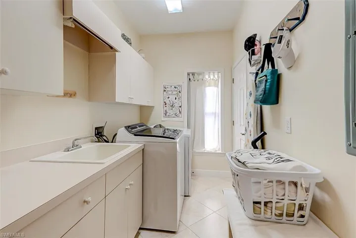 HUGE, SUNNY LAUNDRY ROOM WITH LOTS OF STORAGE AND CONVENIENT UTILITY SINK AND STORAGE CLOSET