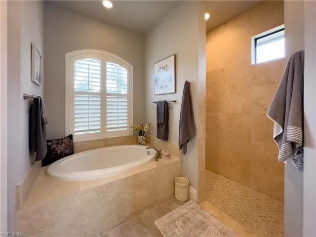 Primary Bathroom featuring relaxing soaker tub, tile floor and walk-in shower