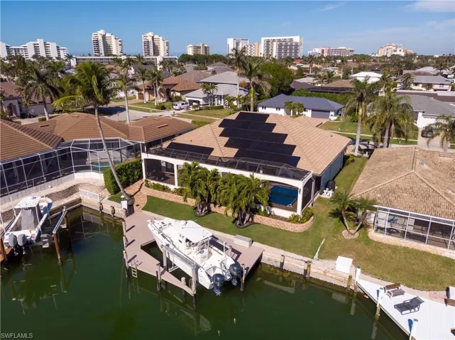 Aerial view of property featuring solar panels and dock