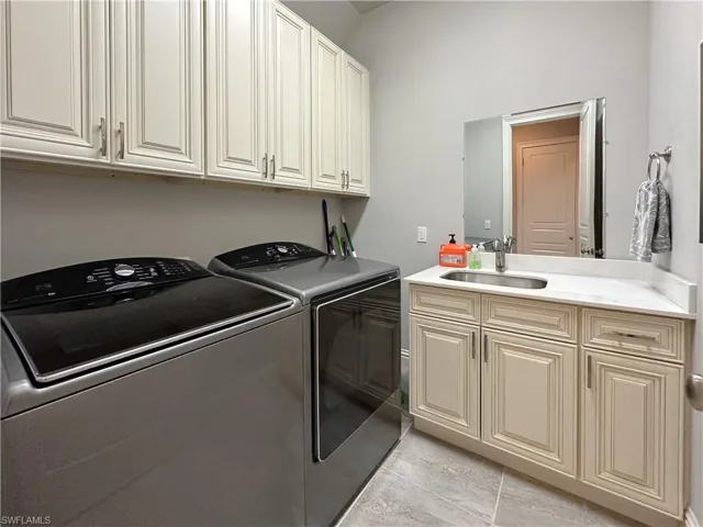 Laundry Center  with sink, cabinets, separate washer and dryer, and tile flooring