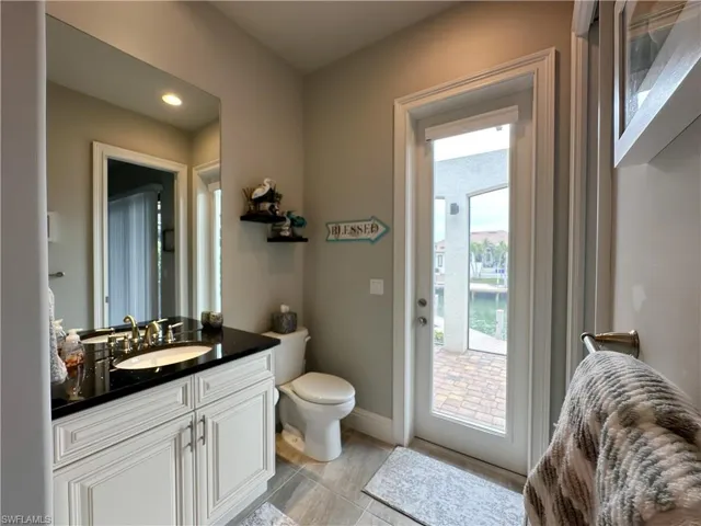 Pool Bathroom featuring toilet, vanity & shower with  access to lanai