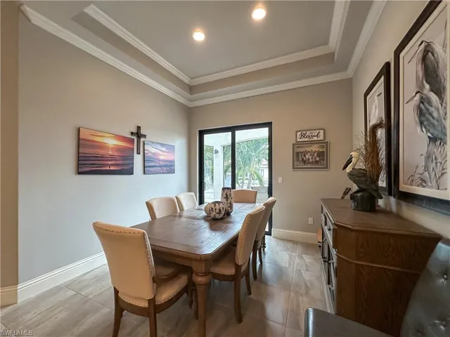 Dining area featuring a raised ceiling and crown molding - view of canal