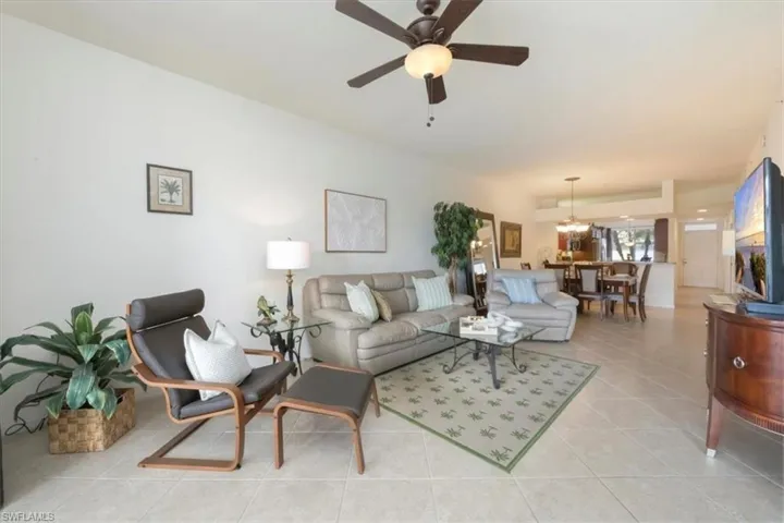 Living room with light tile flooring and a ceiling fan.
