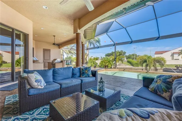 View of patio featuring an outdoor kitchen, ceiling fan, a lanai, and an outdoor hangout area