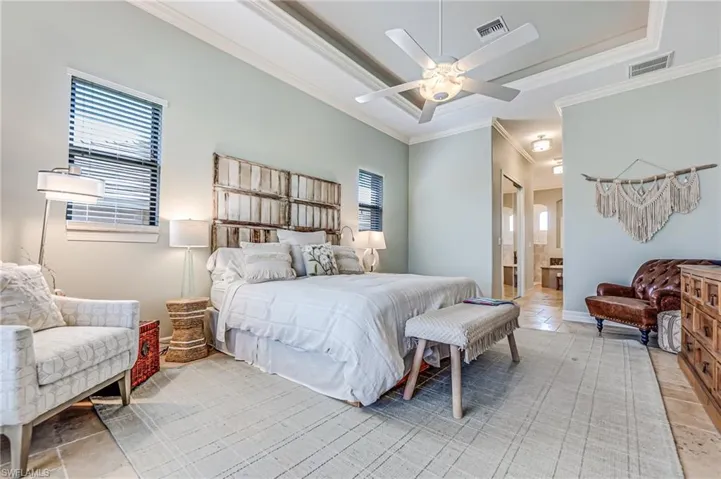 Bedroom with crown molding, ceiling fan, and ensuite bathroom
