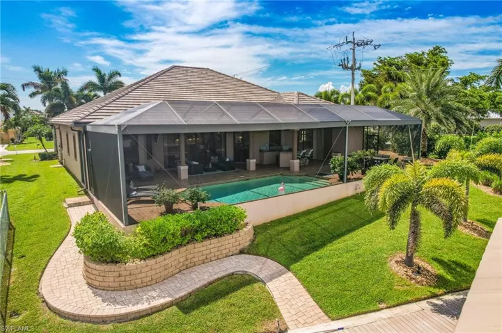 View of pool with glass enclosure, a patio, and a yard
